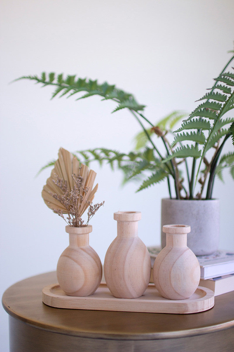 THREE WOODEN BUD VASES ON A TRAY